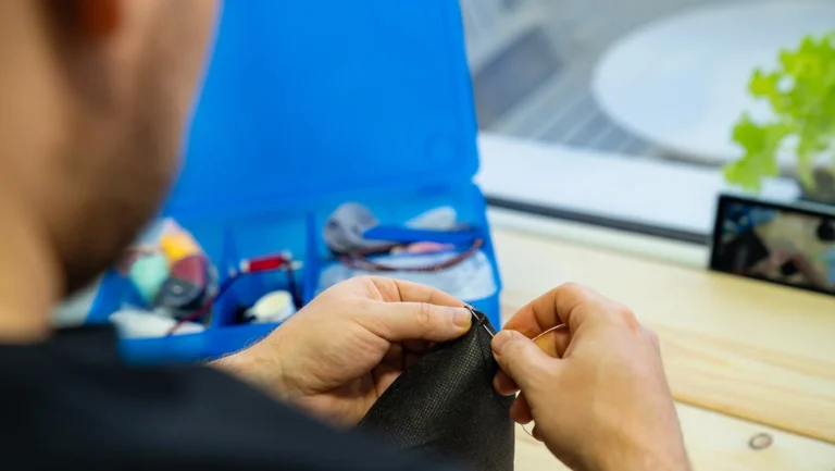 Ręczne zszywanie materiału w pracowni krawieckiej